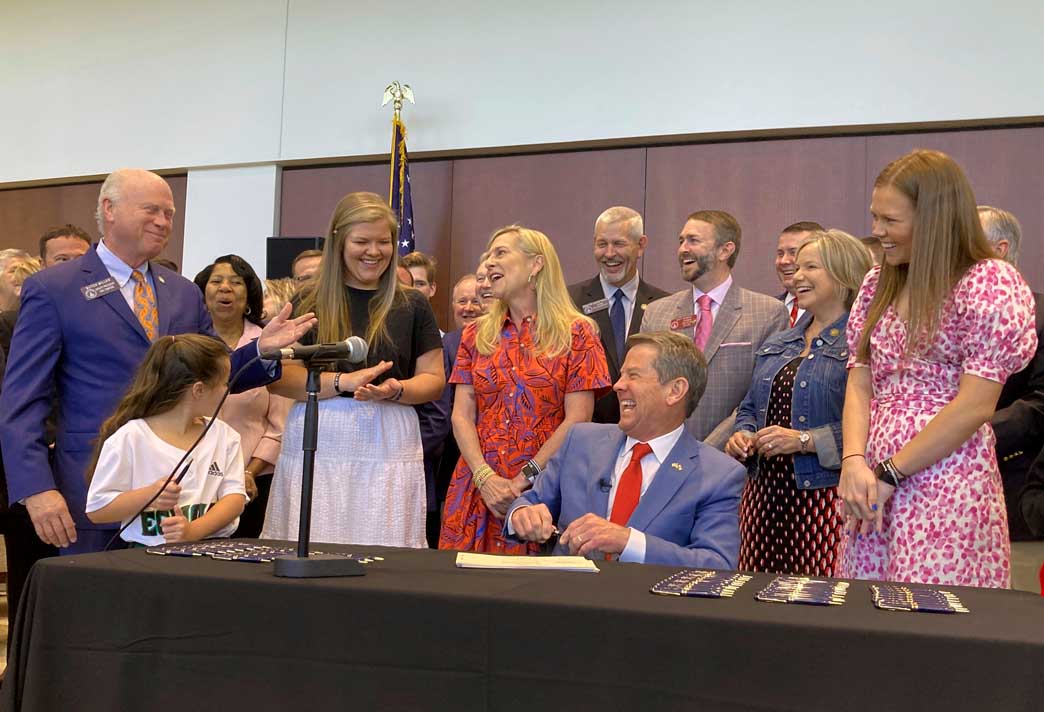 Georgia Governor Brian Kemp laughs after signing  education bill into law