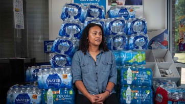 Person in front of cases of water bottles